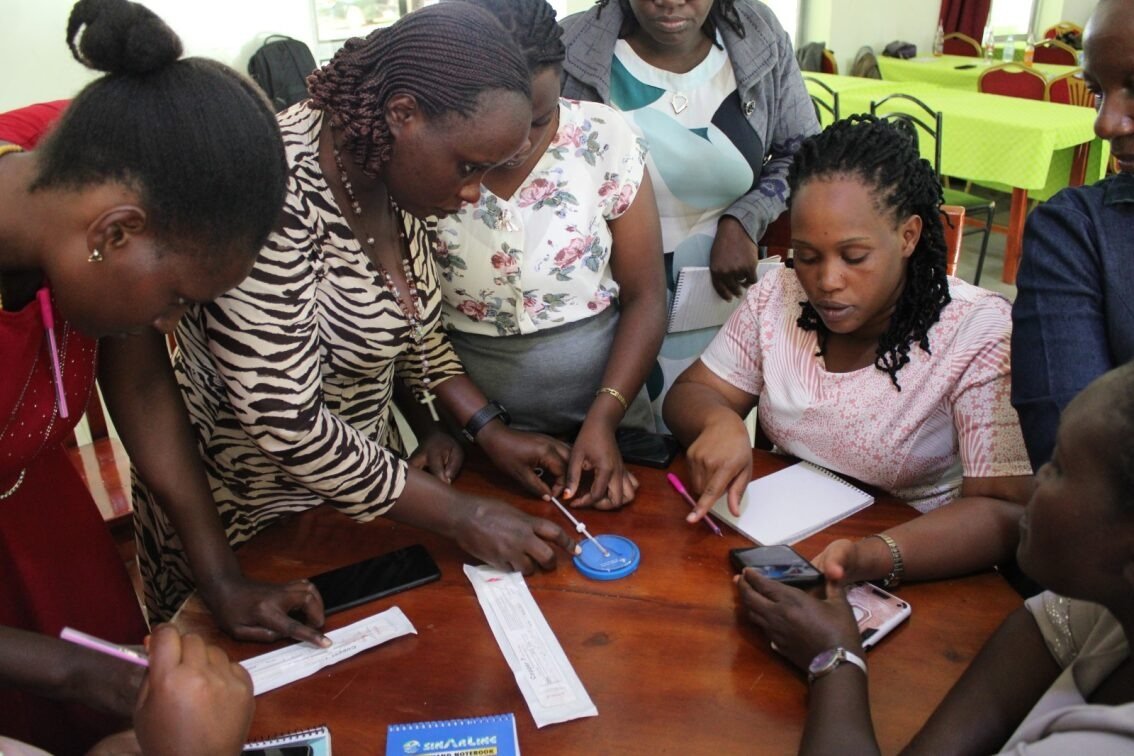 TEGEM staff and community members reviewing family planning materials together